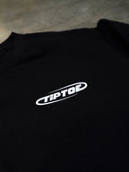 Detailaufnahme des kleinen Frontlogos auf schwarzem Sweater