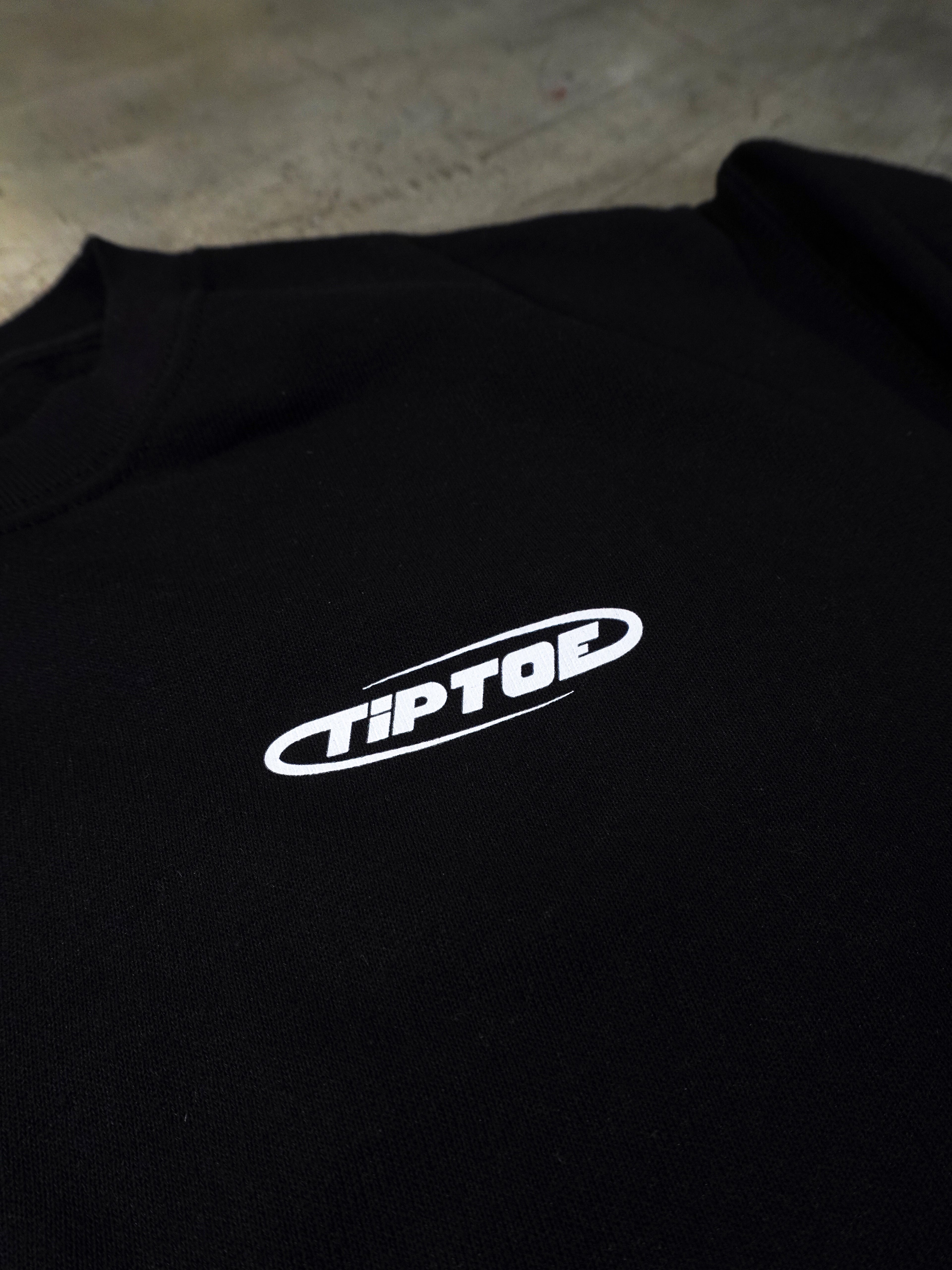 Detailaufnahme des kleinen Frontlogos auf schwarzem Sweater