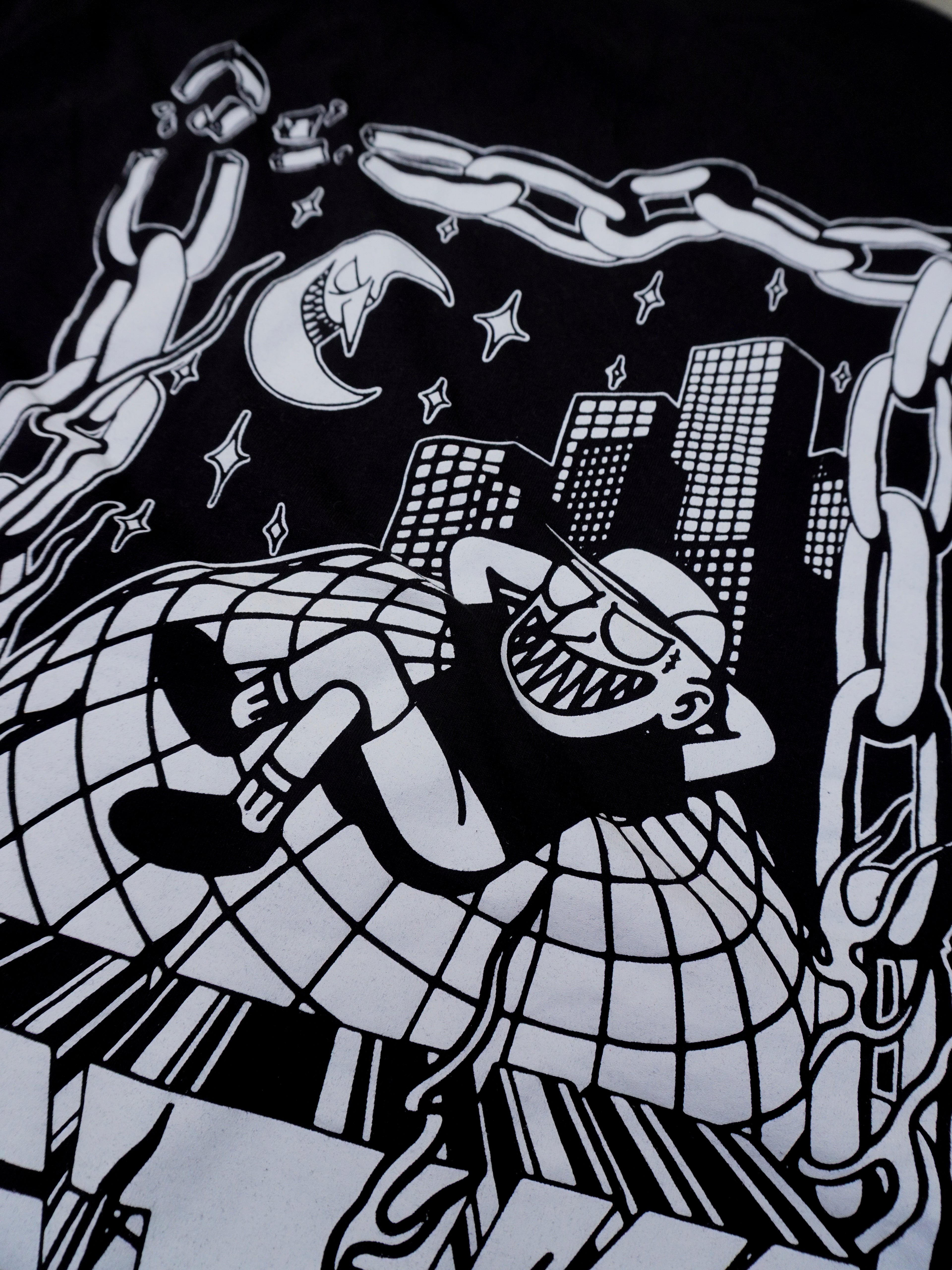 Detailansicht des illustrativen Backprints auf schwarzem Baumwoll-T-Shirt