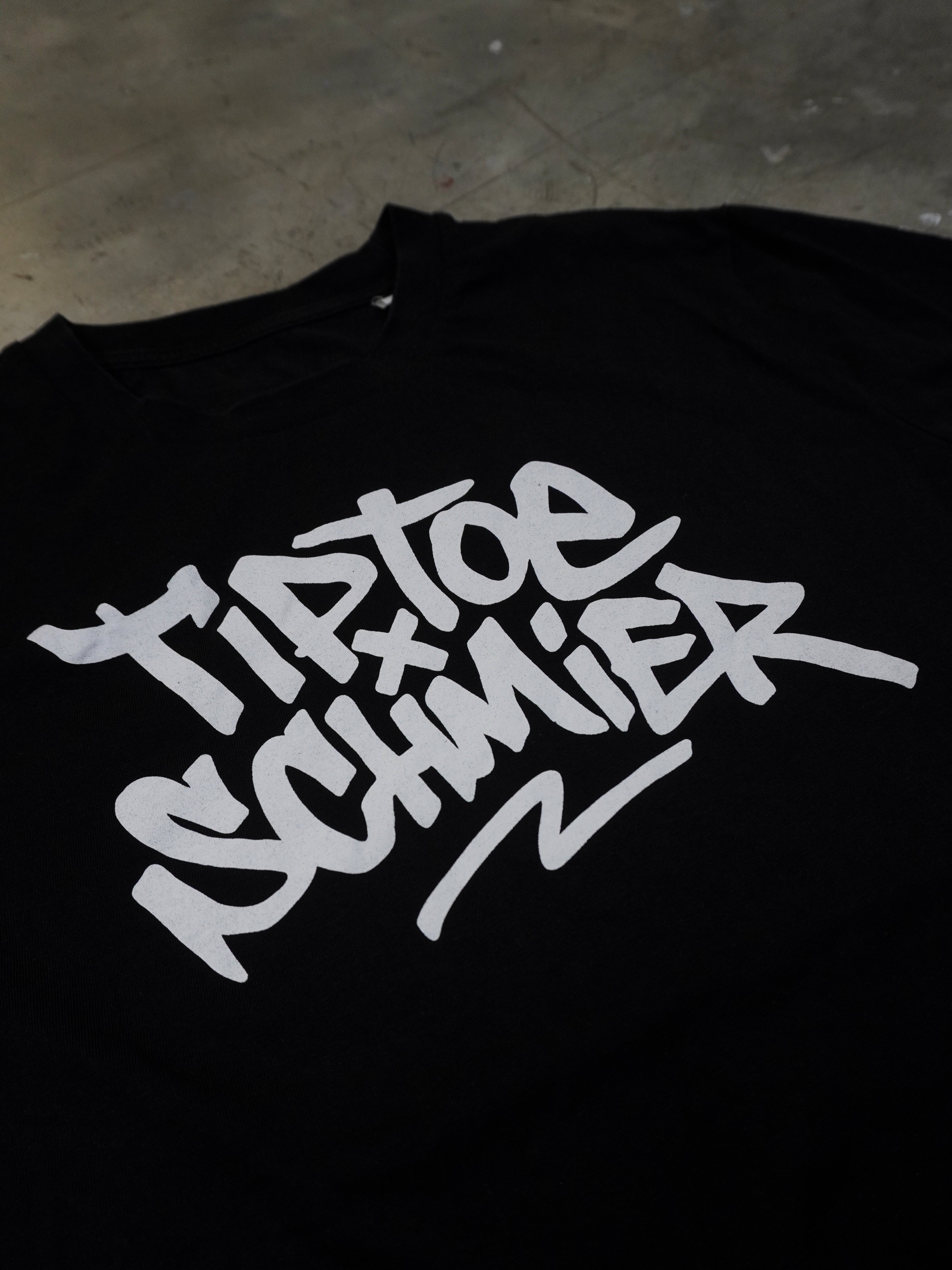 Detailansicht des typografischen Frontprints auf schwarzem T-Shirt