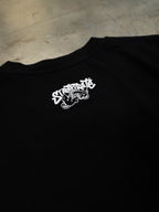 Detailaufnahme des kleinen Prints im Nackenbereich des schwarzen T-Shirts