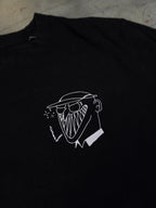Detailansicht des kleinen illustrativen Brustprints auf schwarzem T-Shirt