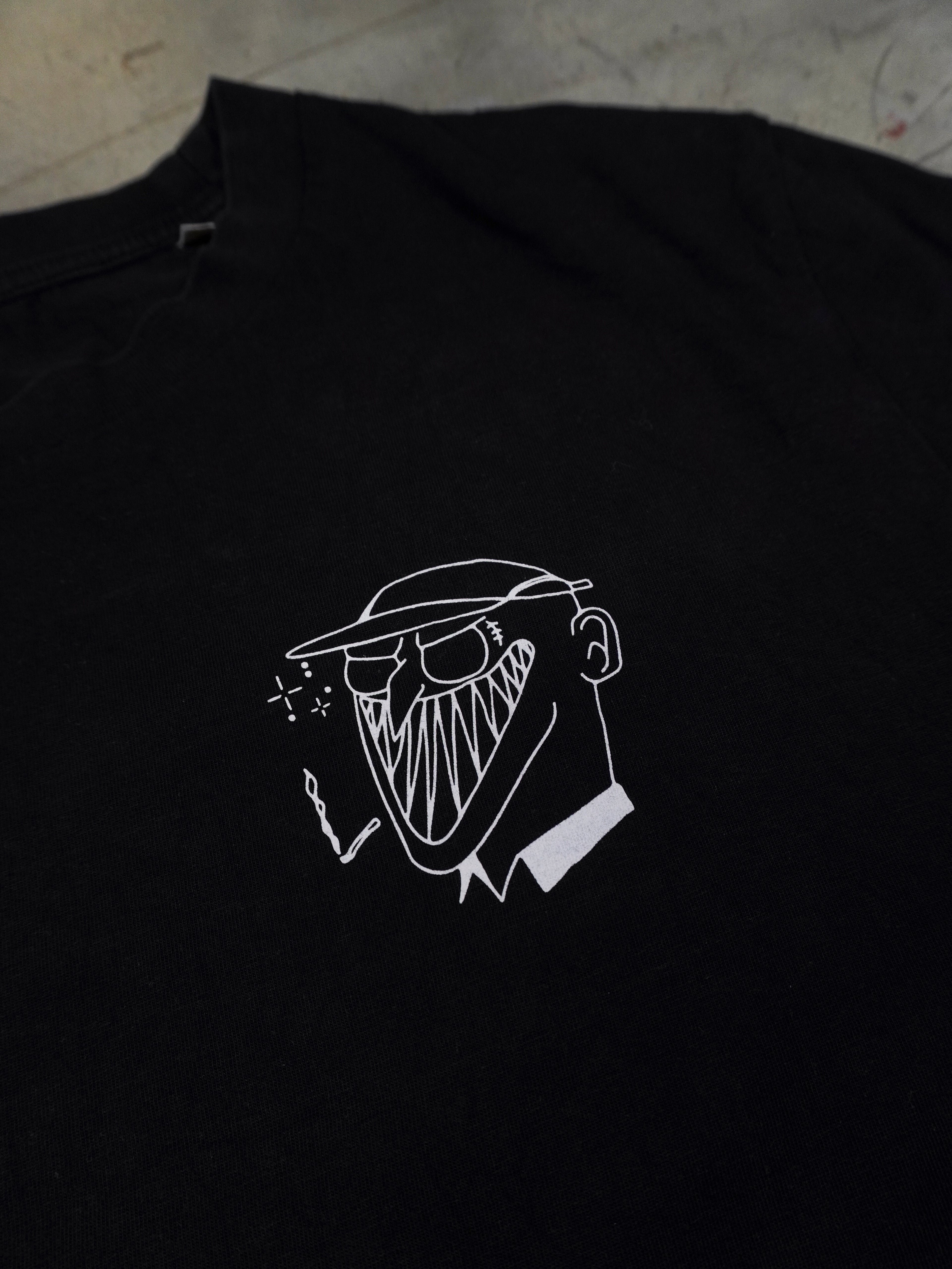 Detailansicht des kleinen illustrativen Brustprints auf schwarzem T-Shirt