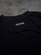 Detailaufnahme des kleinen Nackenlogos auf schwarzem T-Shirt