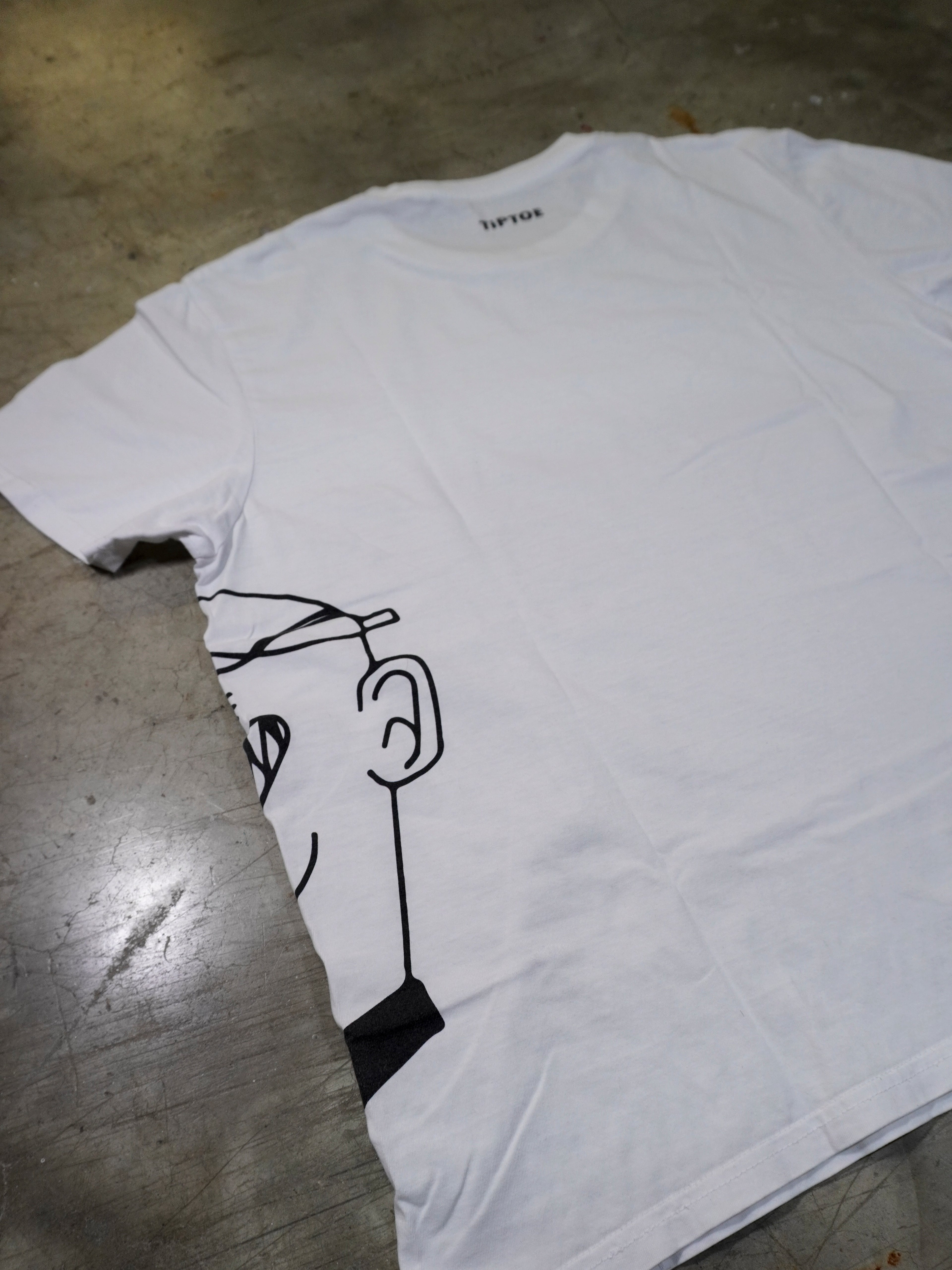 Rückseite des weissen T-Shirts im Flatlay mit seitlichem Print