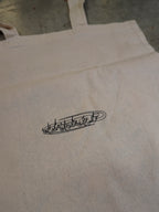 Detailaufnahme des kleinen Logos auf der naturfarbenen Baumwolltasche