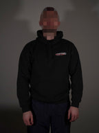 Schwarzer Hoodie mit kleinem Frontlogo getragen von Model in klassischer Passform
