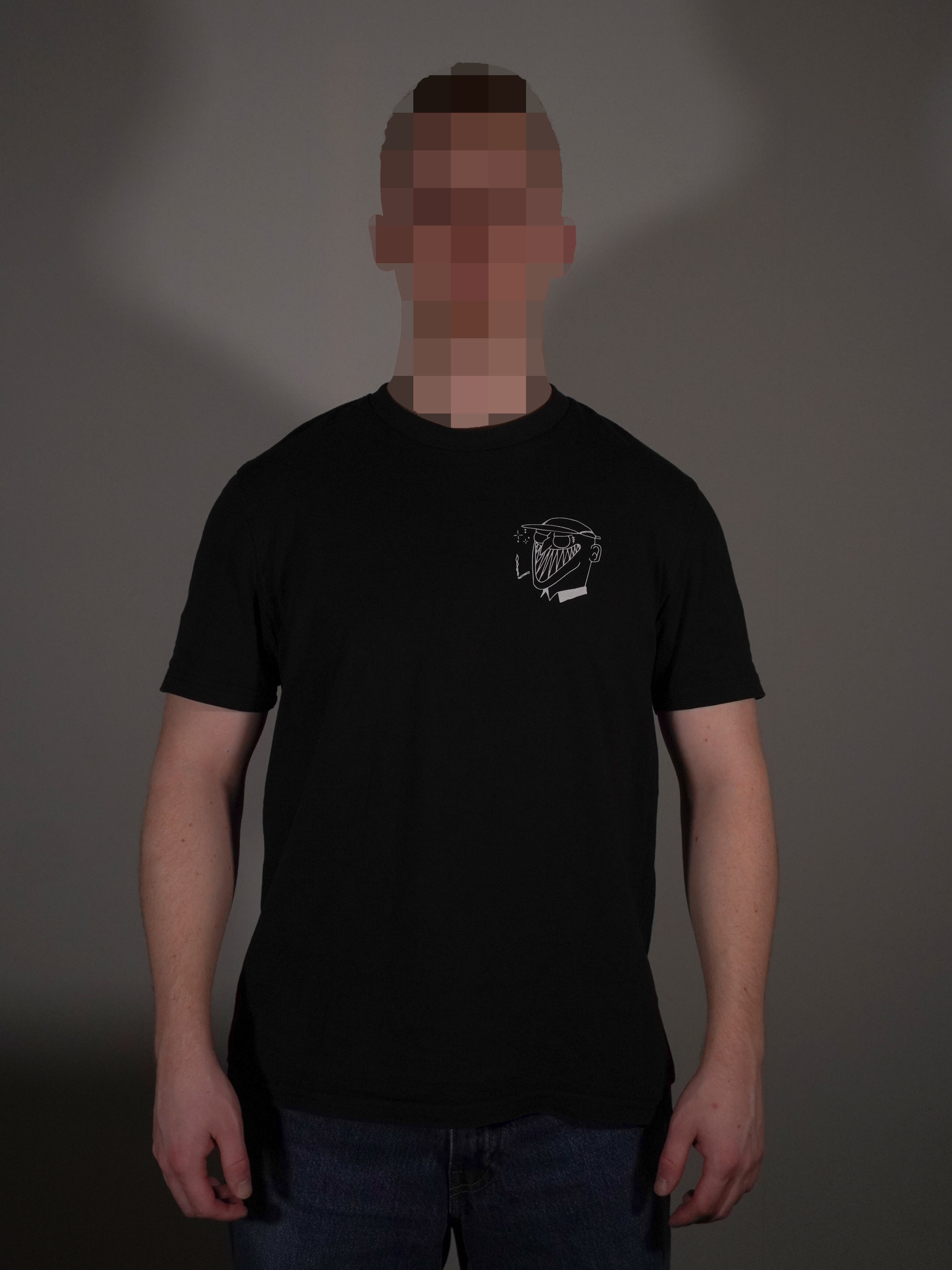 Schwarzes T-Shirt mit kleinem Brustprint getragen von Model in klassischer Passform