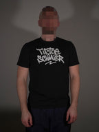Schwarzes T-Shirt mit auffälligem Frontprint getragen von Model in klassischer Passform