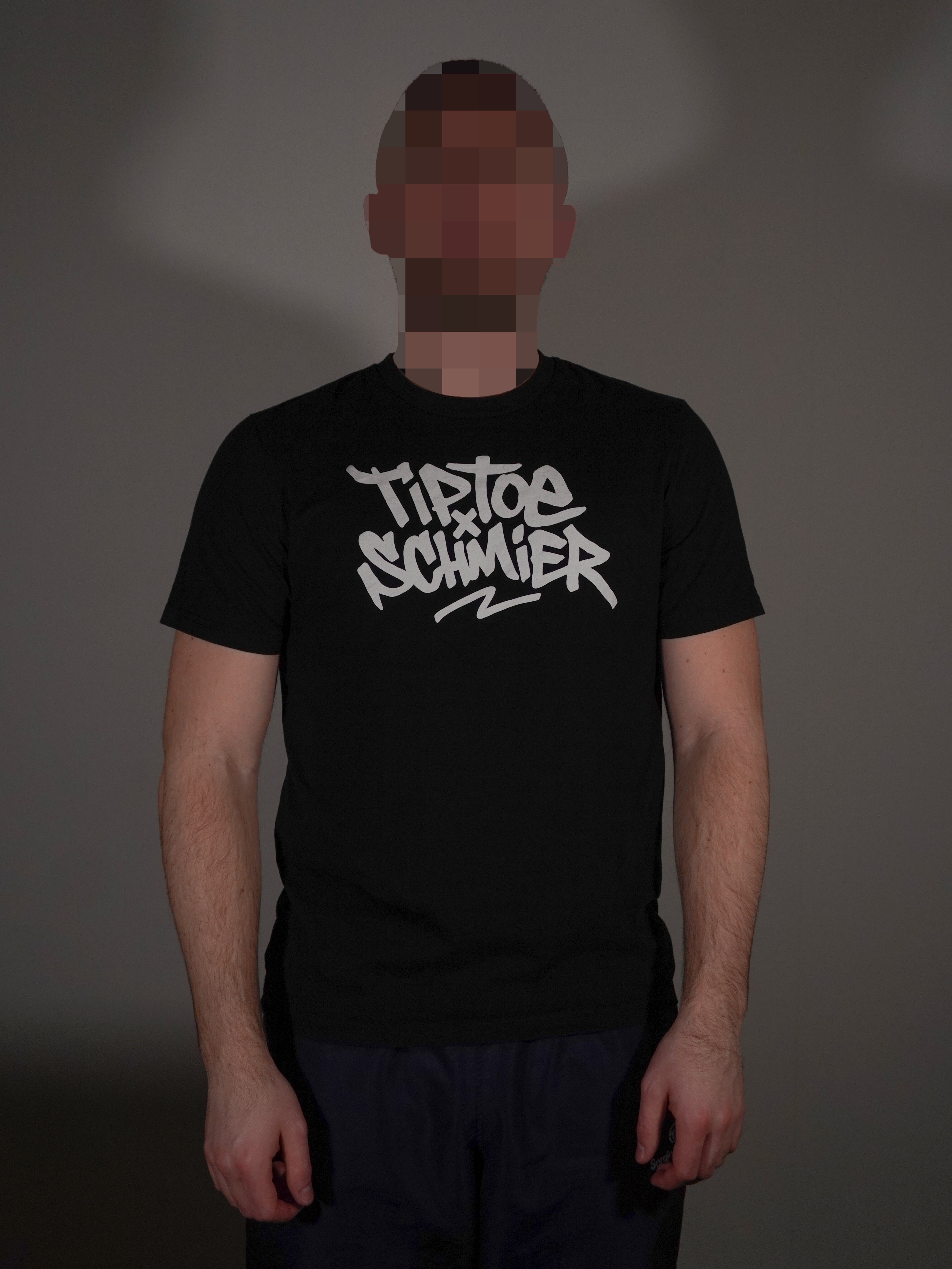 Schwarzes T-Shirt mit auffälligem Frontprint getragen von Model in klassischer Passform